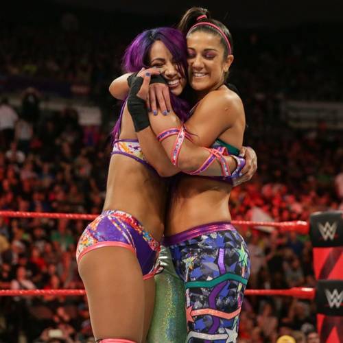 Superluchas - Dos luchadoras, Mercedes Moné y Bayley, abrazadas en el ring mientras luchan.
