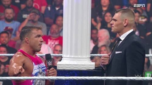 Luchadores de la WWE conversando en un ring durante RAW.