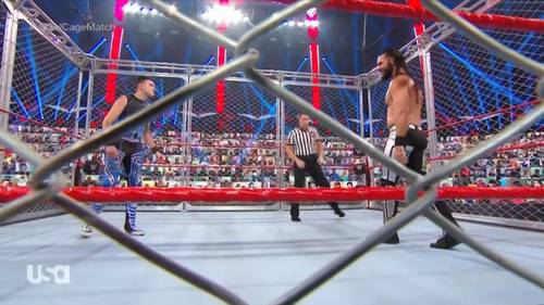 Seth Rollins y Dominik Mysterio luchando dentro de una jaula de acero