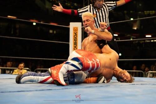 Superluchas - Dos luchadores, Will Ospreay y otro luchador, en un ring de lucha libre con un árbitro.