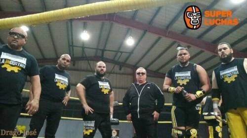 Un grupo de luchadores de pie en un ring de lucha libre.