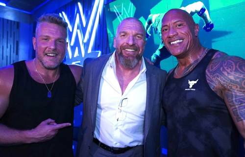 Tres hombres posando para una fotografía en un evento de la WWE.