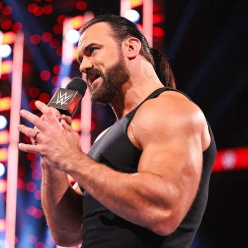 Superluchas - Drew McIntyre, un luchador de la WWE convincentemente poderoso, sosteniendo un micrófono frente a una multitud.