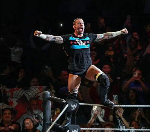 Superluchas - Un luchador con los brazos levantados en el aire frente a una multitud, exudando la energía del &quote;efecto CM Punk&quote;.