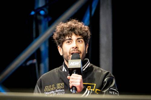 Superluchas - Booker T, un hombre que sostiene un micrófono, está hablando por él.