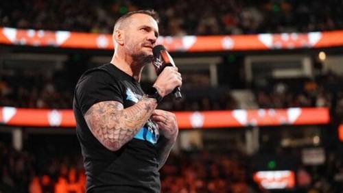 Superluchas - Bully Ray revela la verdadera animosidad entre CM Punk y Seth Rollins, mientras un hombre con tatuajes habla apasionadamente por un micrófono.