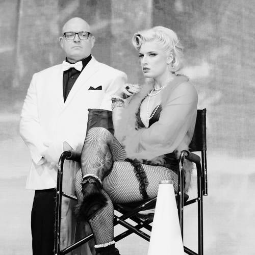 Superluchas - Una fotografía en blanco y negro de Dustin Rhodes y Toni Storm sentados en una silla.