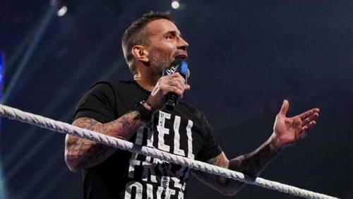 Superluchas - CM Punk, un hombre en un ring de lucha libre, haciendo una promoción con un micrófono.