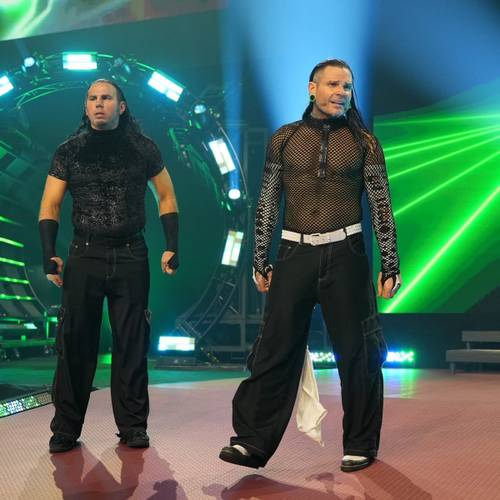 Superluchas - Dos luchadores parados en un escenario con luces verdes, mostrando el presente de The Hardys en AEW.