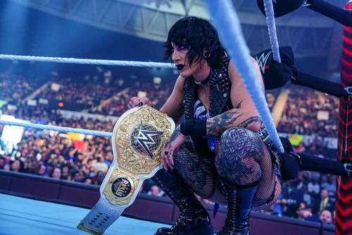 Superluchas - Una mujer en un ring de lucha libre sosteniendo un cinturón de campeonato de la WWE junto a Randy Orton, los rivales soñados de Rhea Ripley en WWE.