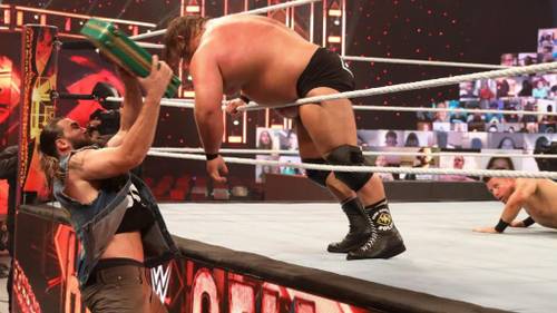 Tucker golpeando a Otis con el maletín Money in the Bank ante la mirada de The Miz en Hell in a Cell 2020 - WWE