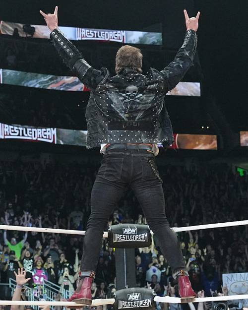 Superluchas - Un hombre con una chaqueta de cuero está parado encima de un ring de lucha libre en AEW.