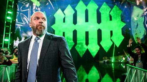 Superluchas - Triple H, un hombre de traje, parado frente a una multitud.