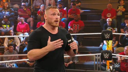 Superluchas - Un luchador se dirige a una multitud apasionada, hablando por un micrófono durante un electrizante evento de WWE NXT el 19 de diciembre de 2023.