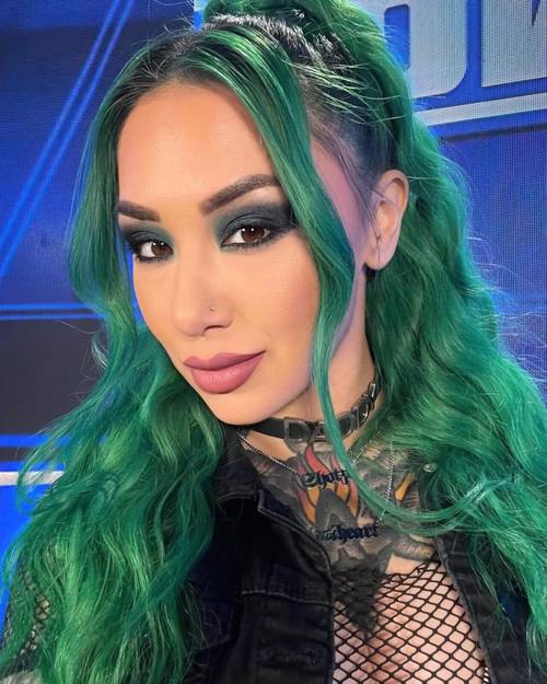 Superluchas - Shotzi, una mujer de cabello verde, posando para una foto.