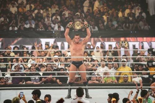 Un luchador sosteniendo su campeonato frente a una multitud en la wwe.