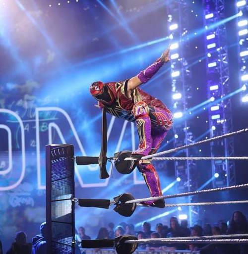 Superluchas - Axiom, un luchador vestido con un traje morado, salta una cerca de alambre de púas durante su pletórica actuación tras su histórico debut en SmackDown.
