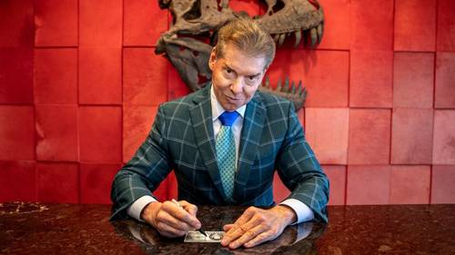Vince McMahon en su despacho firmando dinero