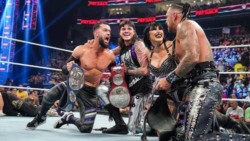 Un grupo de luchadores posando con sus cinturones de campeonato, entre ellos Finn Bálor, quien está decidido a lograr sus objetivos de ganar Money in the Bank y convertirse en Rey del Ring.