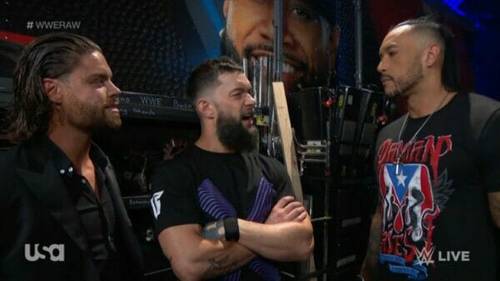 Tres luchadores posan juntos en WWE RAW.