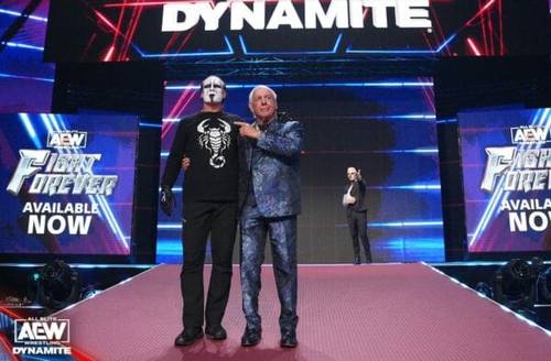 Superluchas - Un hombre de traje parado junto a un hombre que llevaba una máscara de dinamita, pero Eric Bischoff: &quote;AEW es un éxito para Ric Flair&quote;.
