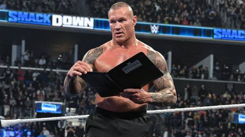Superluchas - Luchador de la WWE sosteniendo un libro frente a una multitud durante su combate. Kurt Angle señala la importancia de Randy Orton para WWE.