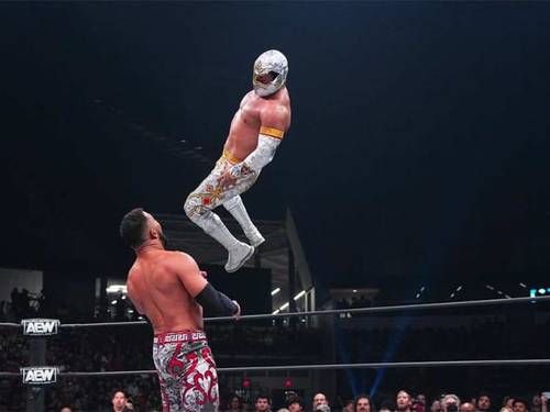 Superluchas - Dos luchadores en el aire realizando movimientos de alto vuelo en un combate de lucha libre.