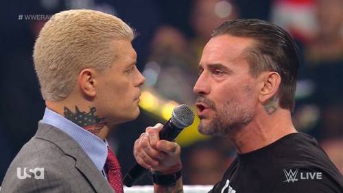 Superluchas - Un hombre sosteniendo un micrófono, entrevistando a otro hombre durante WWE RAW.