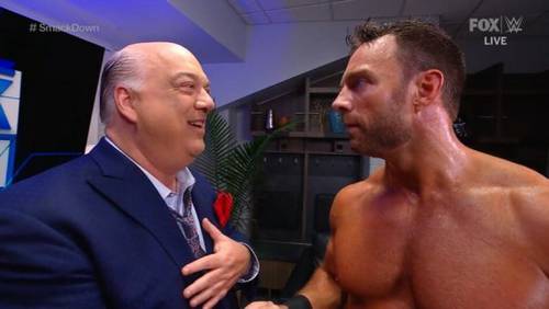 Un hombre de traje le da la mano a otro hombre en WWE SMACKDOWN.