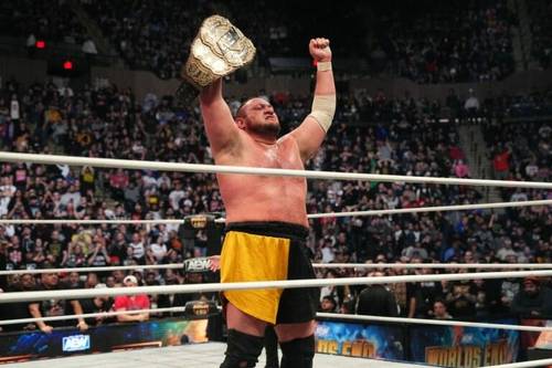 Superluchas - Samoa Joe, el campeón, levanta triunfalmente su cinturón frente a una multitud que lo vitorea mientras el comentarista de lucha libre Jim Ross ofrece comentarios electrizantes.