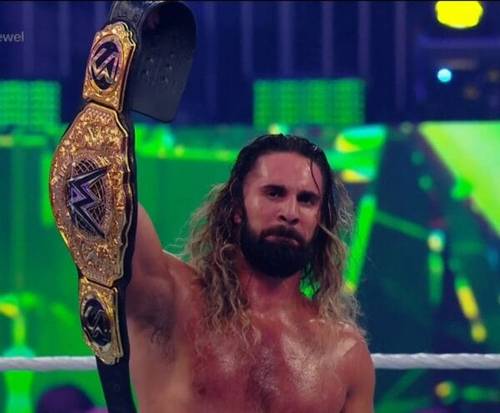 Superluchas - Seth Rollins, con su largo cabello y barba, sostiene triunfalmente el cinturón del Crown Jewel Championship después de retener el Campeonato Mundial de Peso Completo.