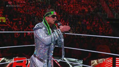 Un luchador con un traje plateado está de pie en un ring durante WWE RAW.