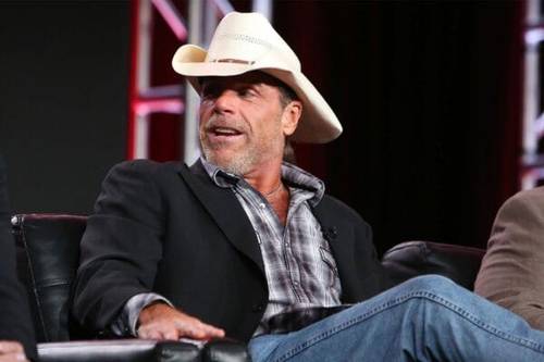 Superluchas - Un hombre con sombrero de vaquero, Shawn Michaels, sentado en una silla.