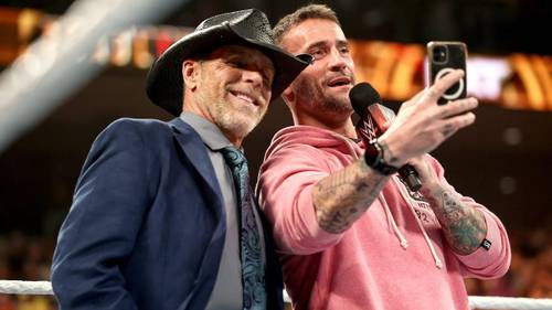 Superluchas - Dos hombres, CM Punk y Booker T, tomándose una selfie en un ring de lucha libre en NXT Deadline 2023.