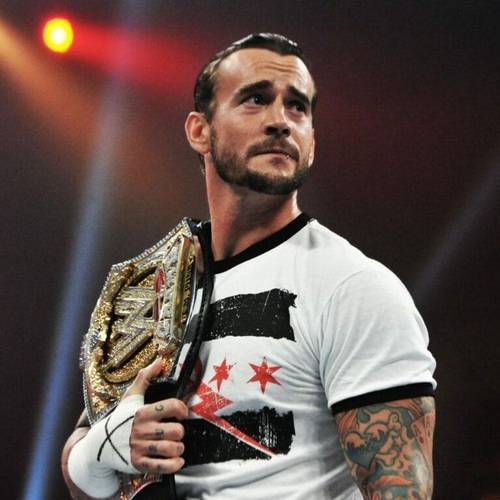 Superluchas - Un hombre con tatuajes sosteniendo un cinturón de lucha libre, mostrando la situación actual entre CM Punk y WWE.