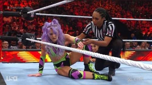 Superluchas - Una luchadora sentada en el suelo con un árbitro, mostrando la intensidad de su combate de WWE RAW el 30 de octubre de 2023.