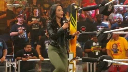 Superluchas - Una mujer sostiene un micrófono frente a una multitud en WWE NXT el 3 de octubre de 2023.