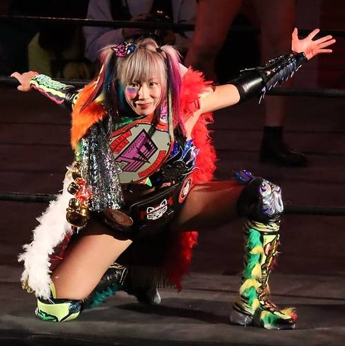 Superluchas - Sayaka, una mujer con un traje colorido, posando en un ring de lucha libre durante una función.