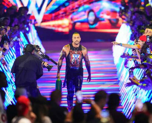 Un luchador de la WWE camina por una pasarela frente a una multitud mientras, según Triple H.