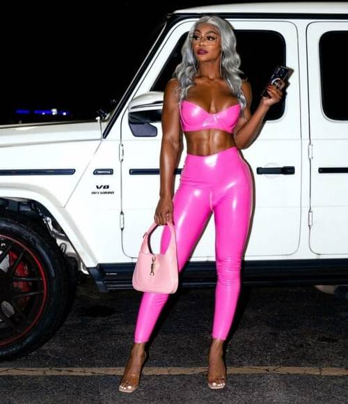 Superluchas - Jade Cargill con pantalones de cuero rosa parada junto a una camioneta blanca en la WWE.