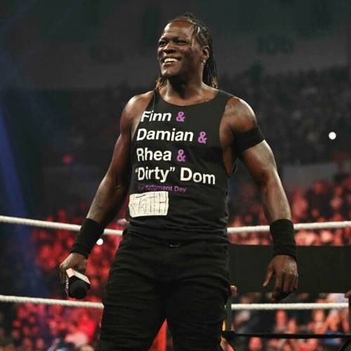 Superluchas - R-Truth, vestido con una camiseta, se encuentra con confianza en un ring de lucha libre.
