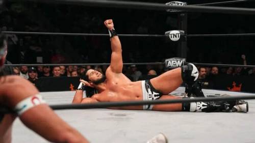 Superluchas - Un luchador está tirado en el suelo en un ring de lucha libre, mientras que Rush quiere enfrentarse a Adam Copeland en AEW All In 2024.