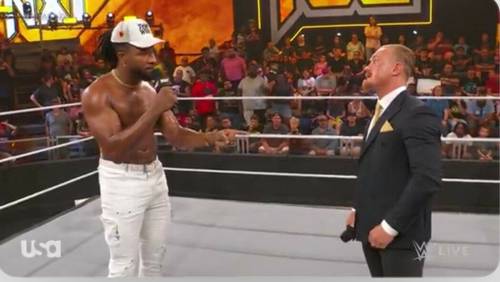 Un hombre está hablando de WWE NXT con otro hombre en un ring de lucha libre.