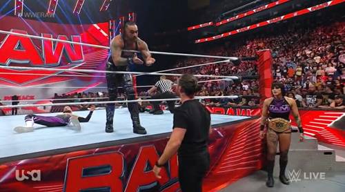 Un luchador y árbitro en el ring en WWE RAW.