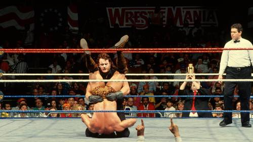 Superluchas - Dos luchadores, incluido el Undertaker, en un ring con un árbitro.