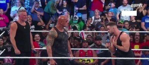 Luchadores de la WWE en un ring hablando entre ellos.