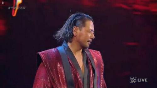 Un hombre vestido con una túnica roja sube al escenario con confianza.