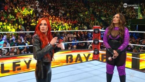 Superluchas - Dos mujeres en un ring de WWE RAW con micrófonos.
